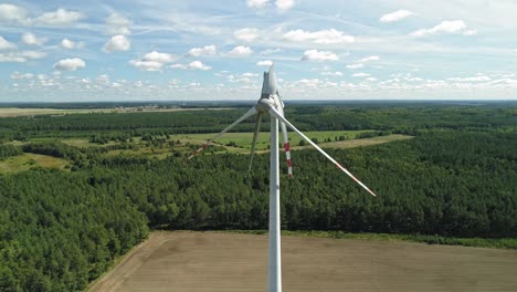 wind turbines with damaged blades against lush vegetation in wiatrak, poland