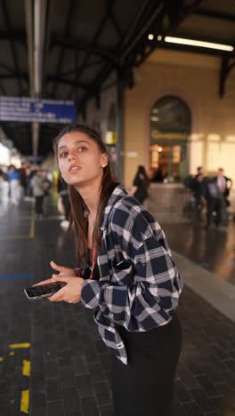 young woman waiting at train station