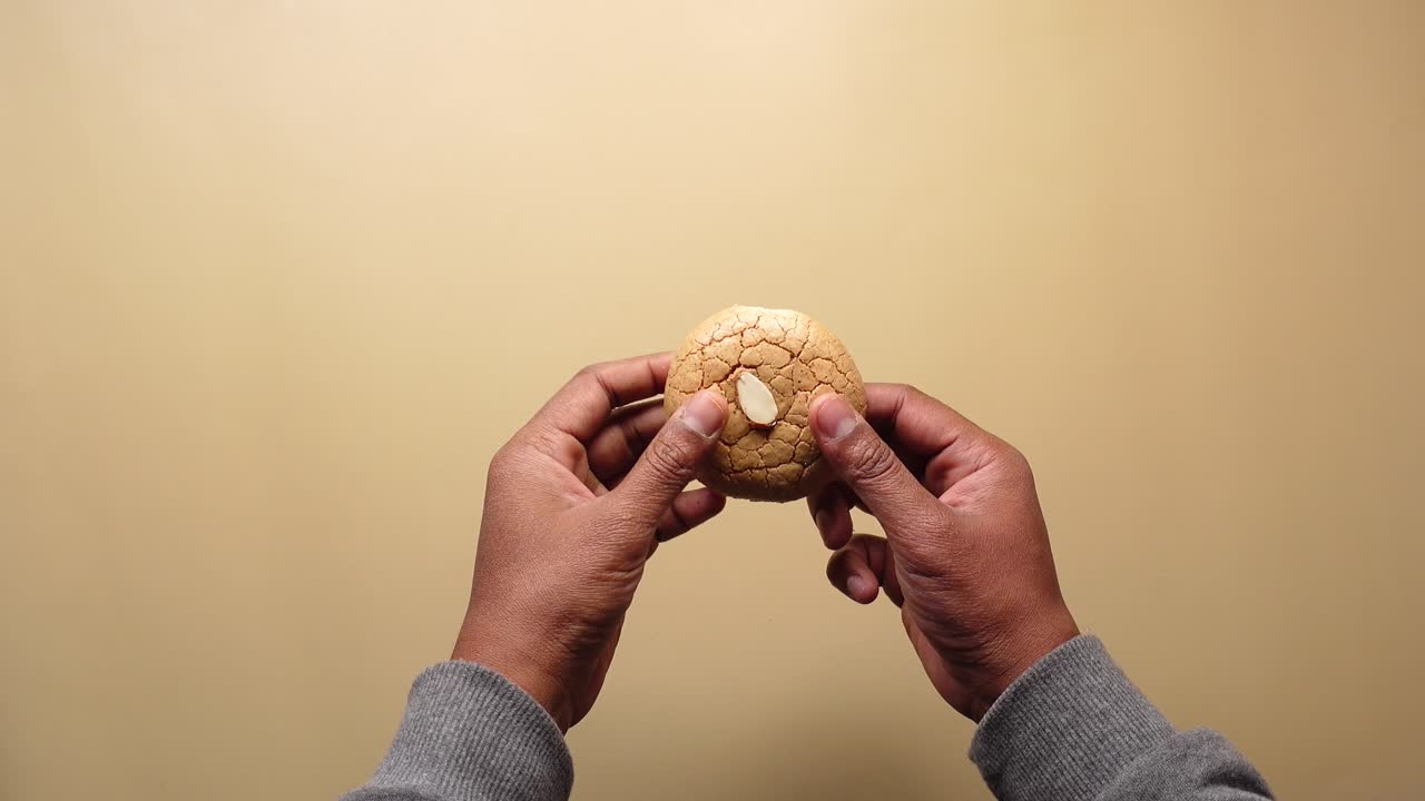 rompiendo una deliciosa galleta de almendras