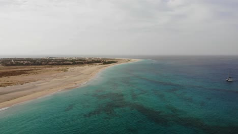 Aerial-View-Over-Beautiful-Blue-Turquoise-Ocean-Waters-Beside-Idyllic-Beach