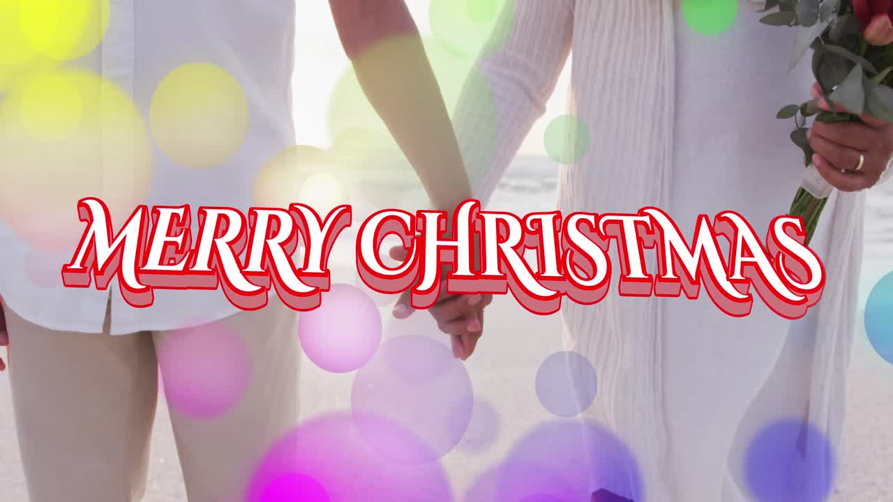 해변에서 시니어 이중 인종 부부 위에 메리 크리스마스 텍스트의 애니메이션