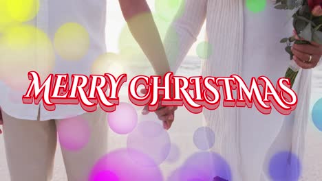 Animation-of-merry-christmas-text-over-senior-biracial-couple-at-beach