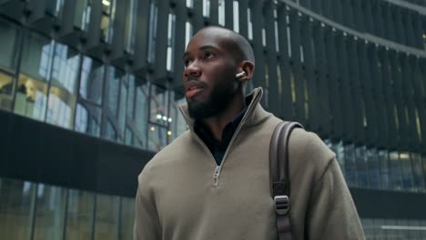 man walking in front of modern office building