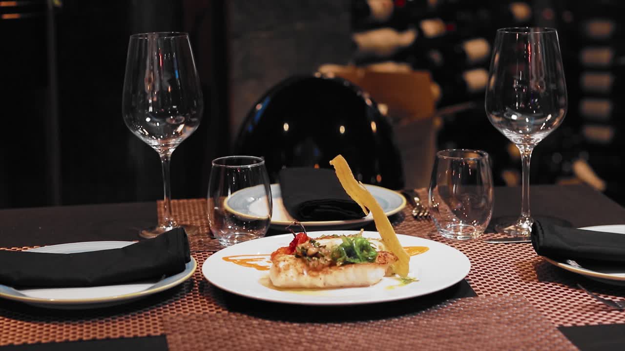 Wide angel haddock's plate on a white plate on the table of a fancy restaurant