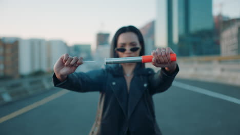 young-woman-lighting-signal-flare-in-city-rebellious-girl-protesting-in-street-with-firework