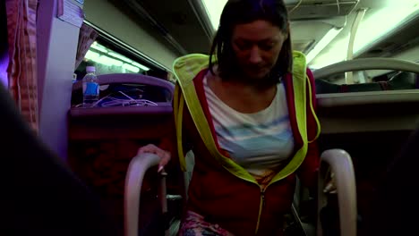 una mujer pasa por el autobús de sueño del salón y se sienta en el lugar