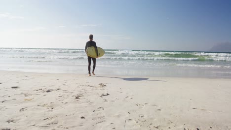 Male-surfer-walking-with-surfboard-at-beach-4k