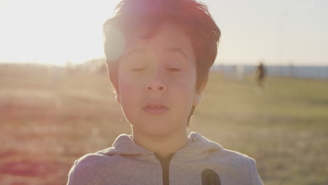 close-up-portrait-happy-boy-playing-running-hands-through-hair-enjoying-warm-summer-day-on-park-sunset