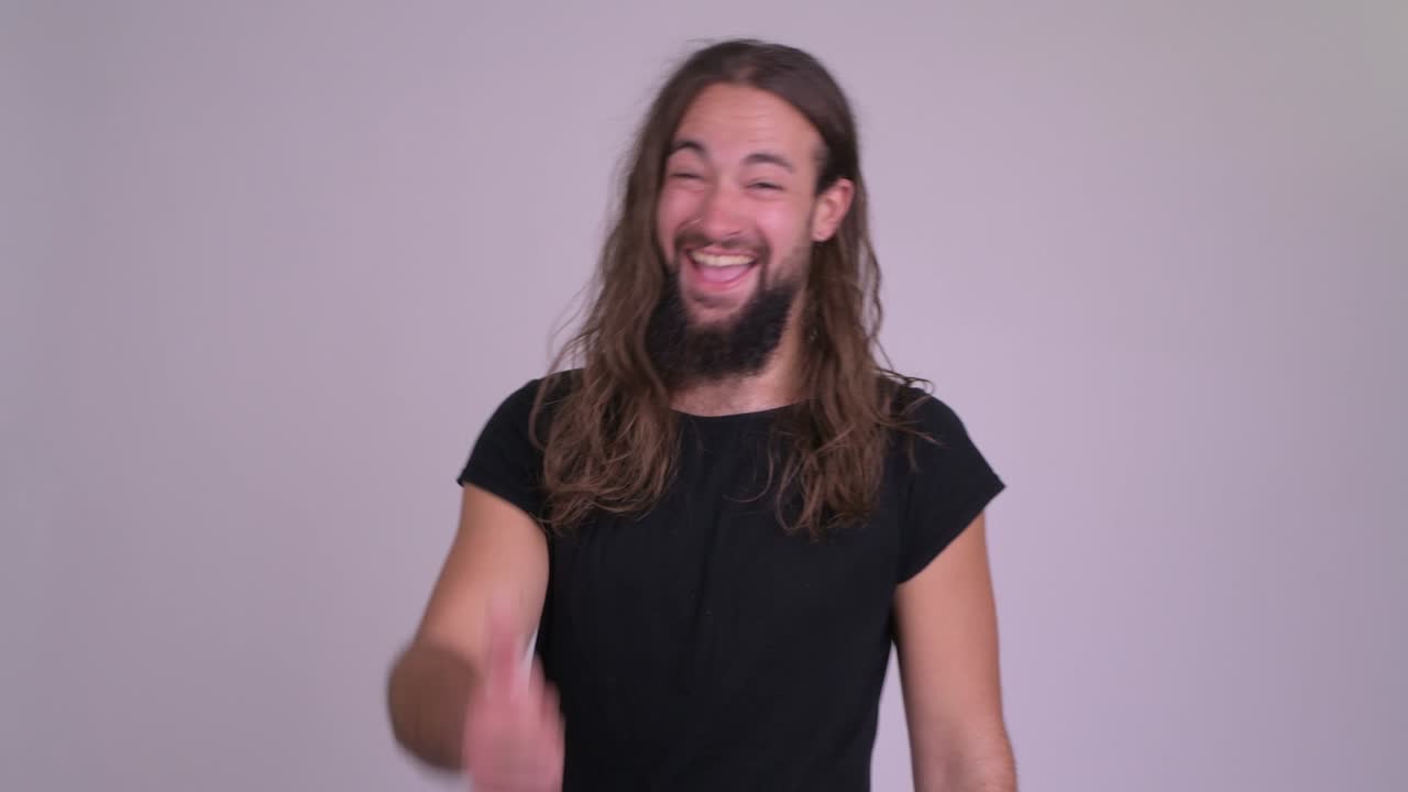 giovane uomo barbuto e bello con i capelli lunghi