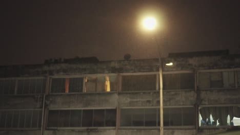 Lloviendo-Por-La-Noche-Con-Luz-De-Calle-Y-Edificio-Antiguo-En-Cámara-Lenta-De-Fondo