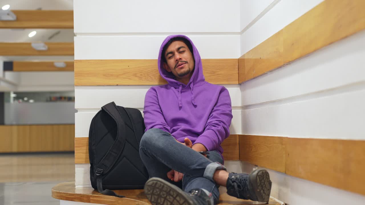 Homem cingalês alegre sentado e esperando, vista frontal.