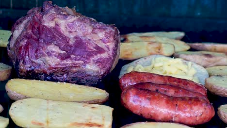 Primer-Plano-De-Carne-A-La-Parrilla-Con-Chorizos,-Tortillas-De-Queso,-Frijoles-Guatemaltecos-Y-Papas-Asadas-Ahumadas-Y-Preparación-Jugosa-Lista-Para-Comer-En-Familia-En-Un-Día-De-Temporada-De-Verano-[hd1920-X-1080]-Fps-29