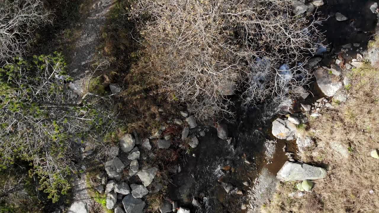 항공: 산에서 두 명의 등산객이 있는 강과 길의 절정 샷