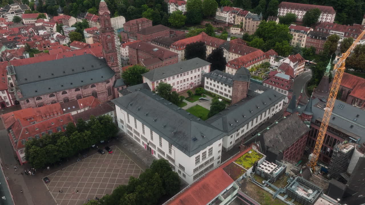 Drone rising pullback from historic courtyard revealing church and old town