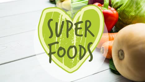 Animation-Von-Superfoods-Text-In-Grün-Auf-Grünem-Herzen,-über-Frischem-Gemüse-Auf-Weißen-Tafeln
