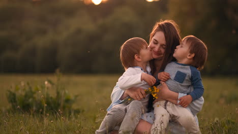 Mutter-Umarmt-Ihre-Beiden-Söhne-Im-Sonnenuntergang-Auf-Dem-Feld.-Liebevolle-Kinder,-Glückliche-Mutter