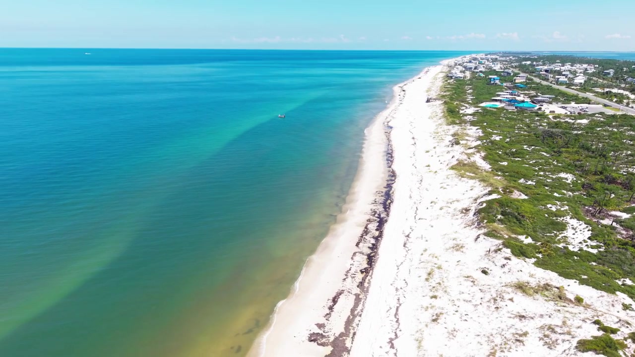 Panoramisk drönarflygning över Mexikanska golfens tropiska miljö, med Cape San Blas strand och det avlägsna kustområdet vid St. Joseph Bays smala halvö, Florida, USA.