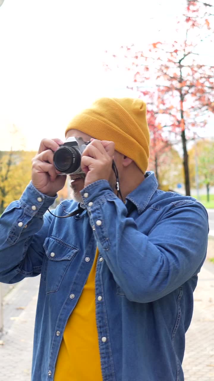 Uomo che scatta una foto con una macchina fotografica analogica