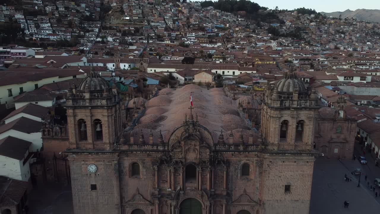 Sweeping aerial pullback from Cusco Cathedral, Peru, cityscape and mountainous backdrop