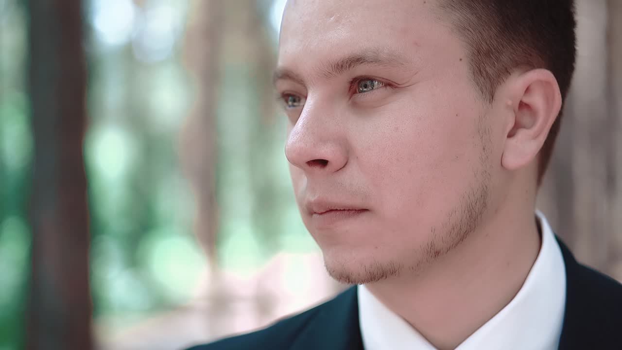 나무 사이 에 서서 멀리 를 바라보는 젊은 남자