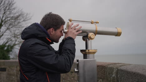 man using viewing scopes on a lookout point, mont-saint-michel, france