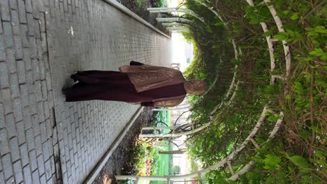a person walking under a lush green archway in a park