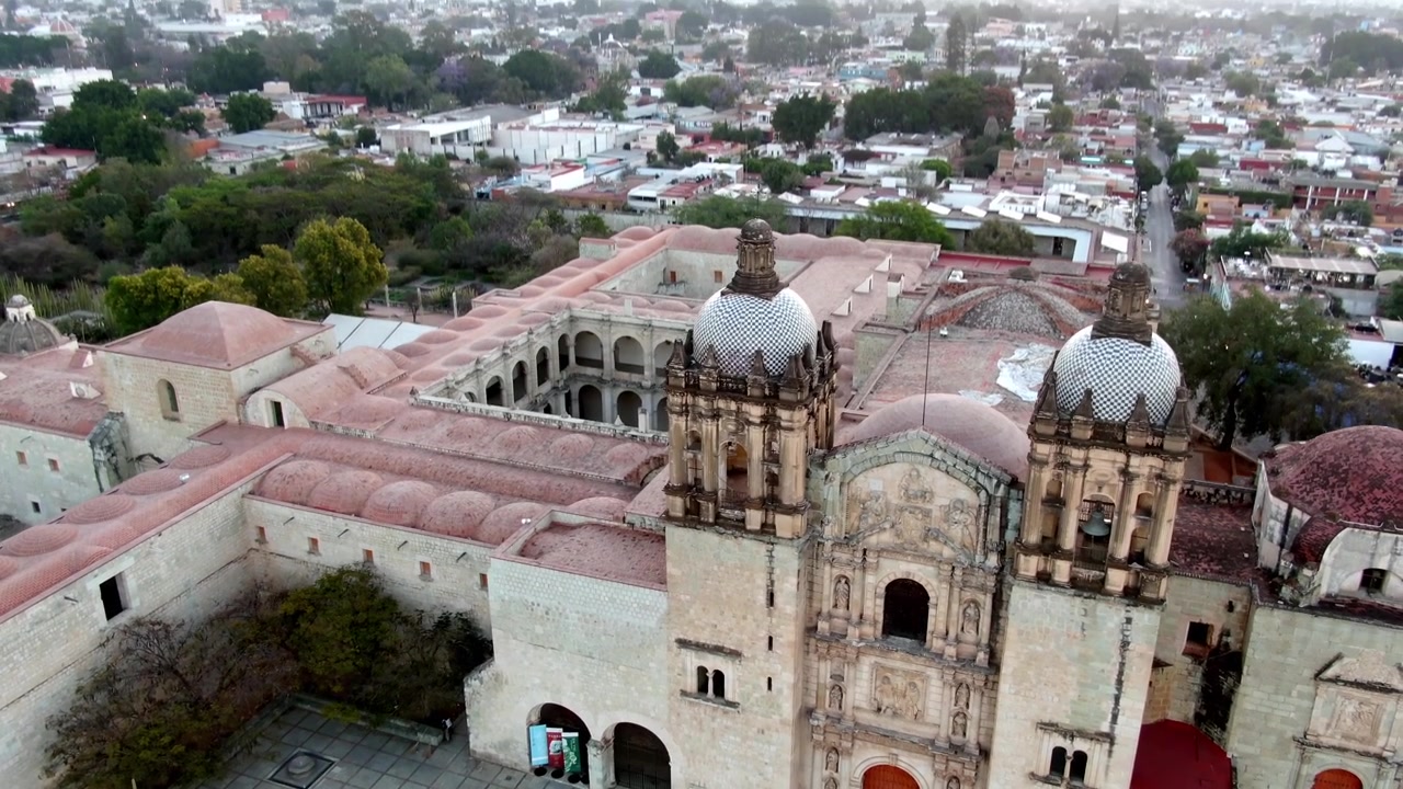 Oaxaca, Meksika'da sabahın erken saatlerinde Oaxaca Şehri ile çevrili Santo Domingo de Guzman Kilisesi ve eski manastır kompleksinin havadan drone görünümü.