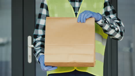 A-Courier-In-Gloves-Holds-A-Bag-Of-Food