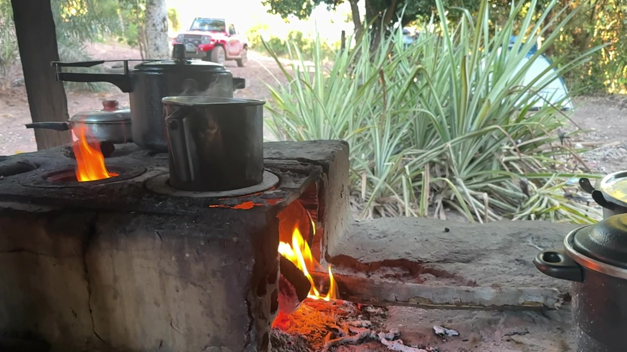 Yemek hazırlığı, geleneksel kamp ateşi, dumanlı yakıtlar, yanan odun, ağır çekim görünüm.