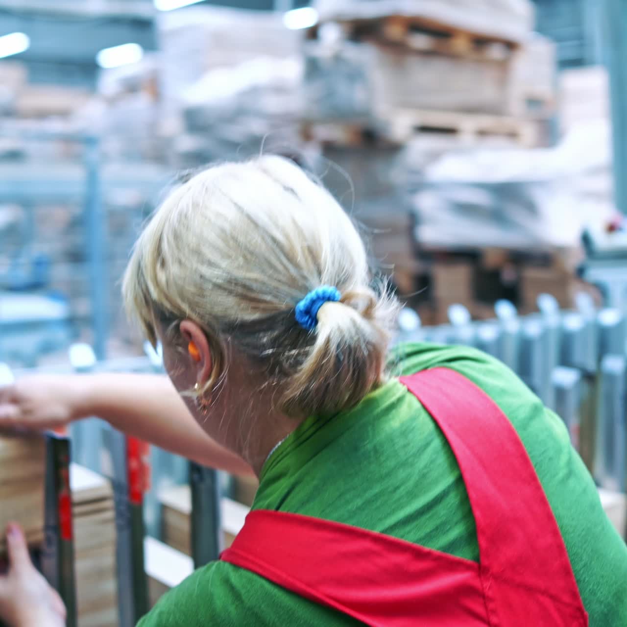 Female worker putting small wooden boards. Interior of industrial factory of furniture production.