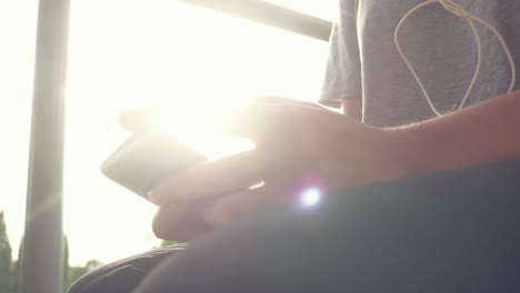 una hermosa joven asiática escuchando música en un teléfono inteligente en la ciudad. una joven asiática relajándose escuching música en la calle.
