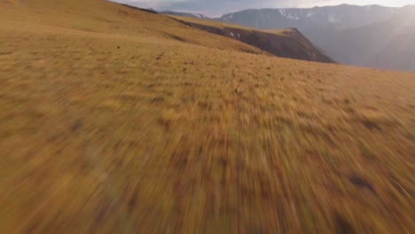 Dramatic-Tilt-Up-Aerial-View-on-Mountainous-Hills-Under-Amazing-Sky-on-Golden-Hour