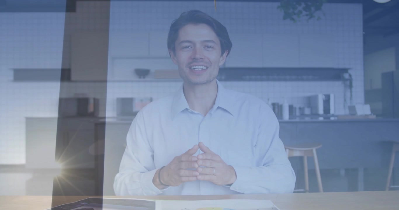 Uomo che presenta nel suo ufficio domestico, toccando un tablet e mostrando grafici sull'energia con una sovrapposizione di turbina.