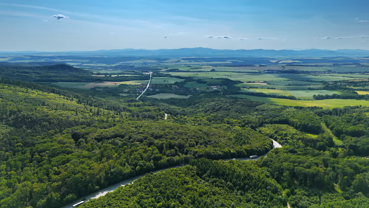 Green valleys with a river. Expansive view of lush valleys and a meandering river under a clear blue sky, showcasing the beauty of nature