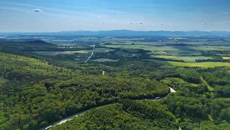 green valleys with a river. expansive view of lush valleys and a meandering river under a clear blue sky, showcasing the beauty of nature