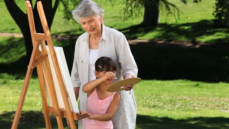 Pretty-girl-painting-a-canvas-with-grandmother