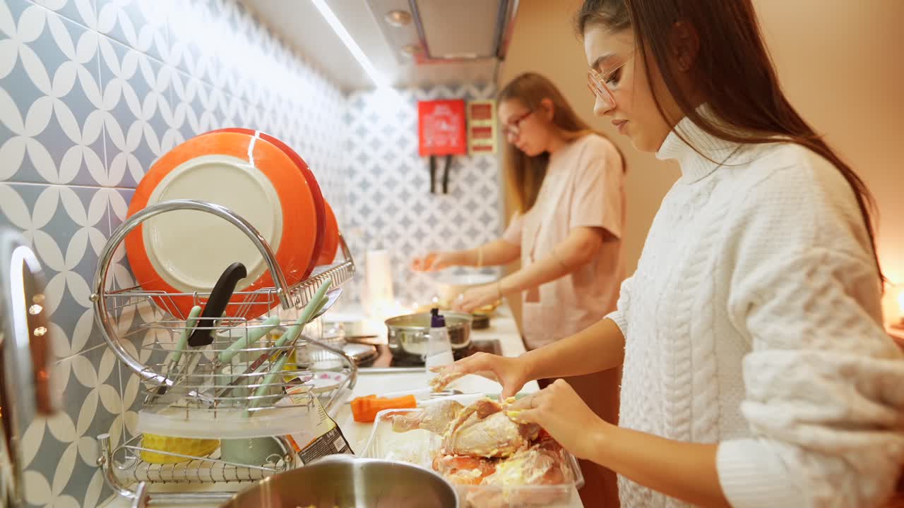dos mujeres jóvenes preparando una comida en una cocina