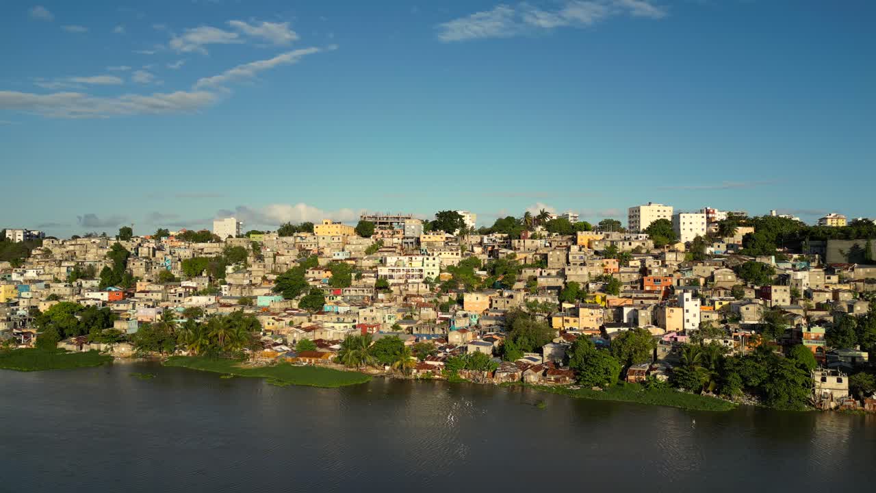 La Zurza, densely populated neighborhood on Ozama River bank in Santo Domingo, urban settlements, Dominican Republic. Aerial drone lateral view, copy space