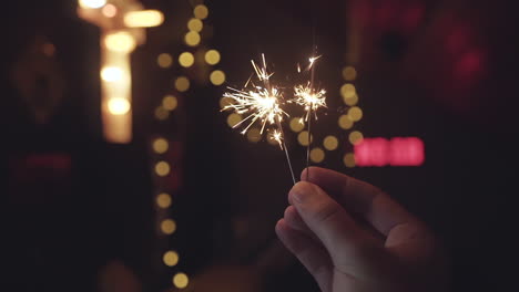 Helle-Wunderkerzen,-Die-In-Zeitlupe-Im-Dunkeln-Mit-Lichtern-Mit-Bokeh-Und-Verschwommenem-Hintergrund-Abbrennen