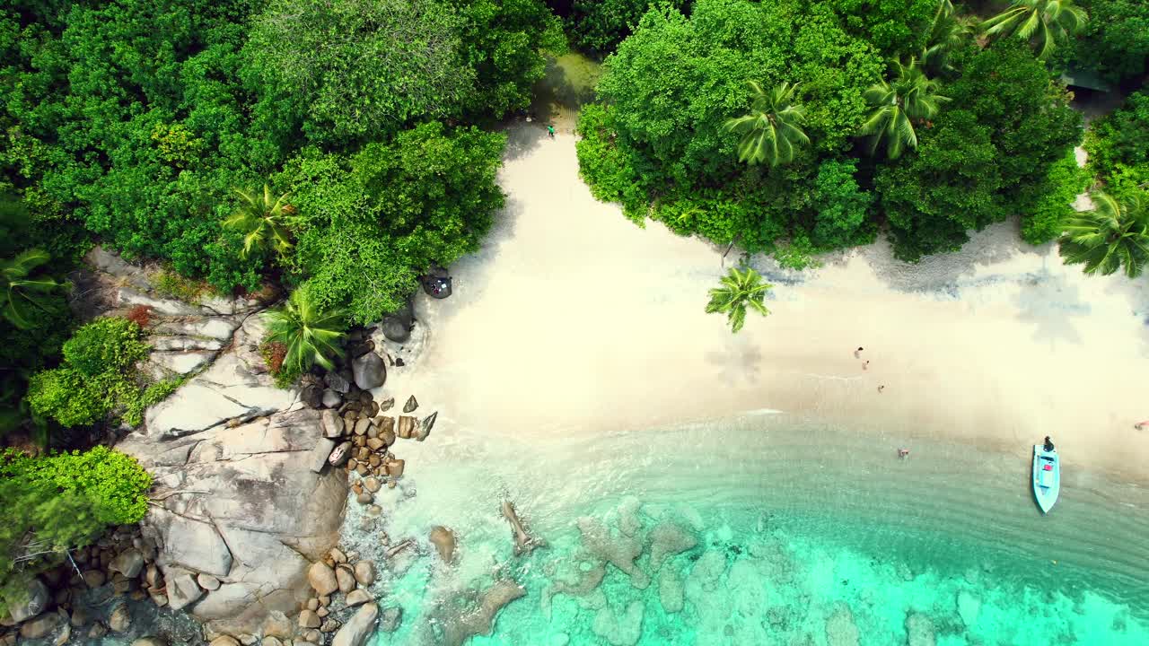 Ripresa aerea da drone di una spettacolare spiaggia a Mahé, Seychelles, con clienti sulla sabbia.