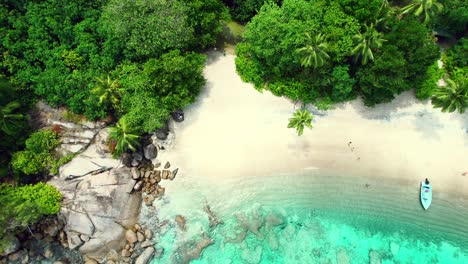 Mahe-Seychelles-major-beach-reveal-drone-shot,-clients-on-the-beach