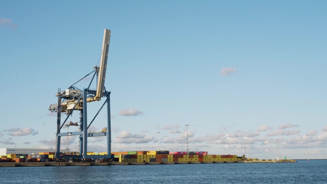 Industrial container crane and colorful shipping containers at commercial port, logistics and trade