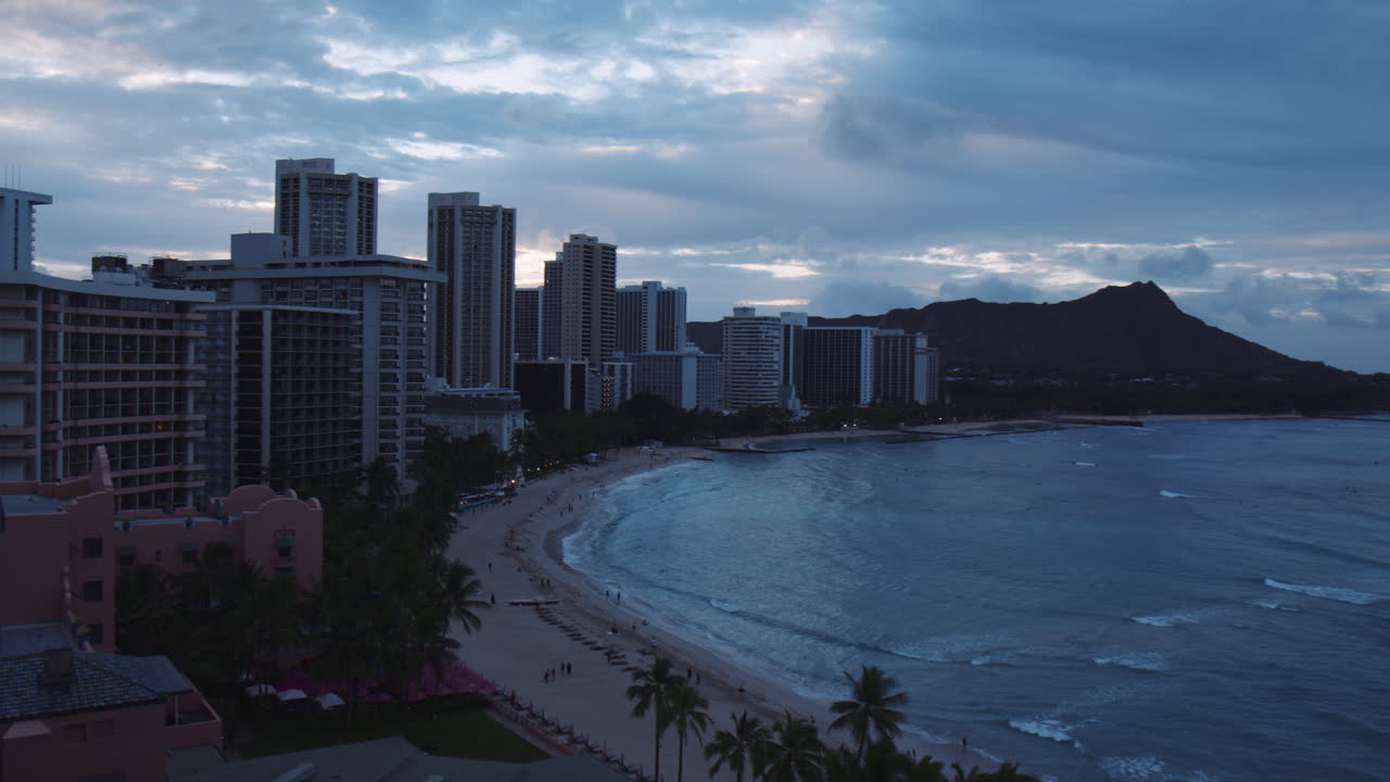 Hotel e resort sulla spiaggia di Waikiki con Diamond Head sullo sfondo, un panorama suggestivo all'alba, panoramica a destra, Hawaii.