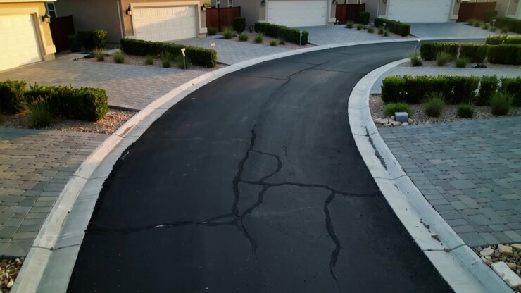 Opening on cracks, camera pulling back revealing curved street with crack repairs and garages