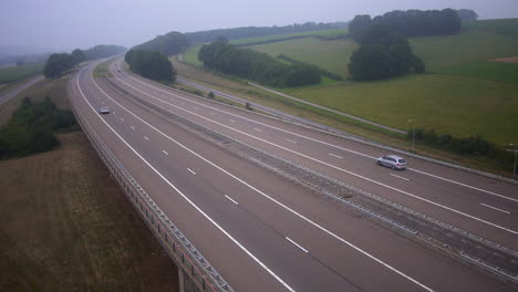 DMC-DeLorean-driving-on-Highway-in-hilly-landscape,-seen-from-above