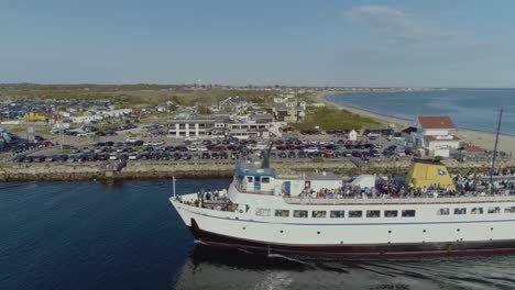 Aerial-of-a-block-island-ferry-boat-entering-a-harbor-in-rhode-island-with-passengers-during-the-summer-time