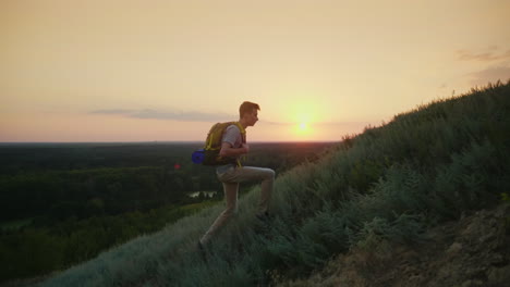 The-Guy-The-Teenager-With-A-Backpack-Climbs-Up-The-Montaña-At-Sunset-Active-Way-Of-Life-Since-Youth