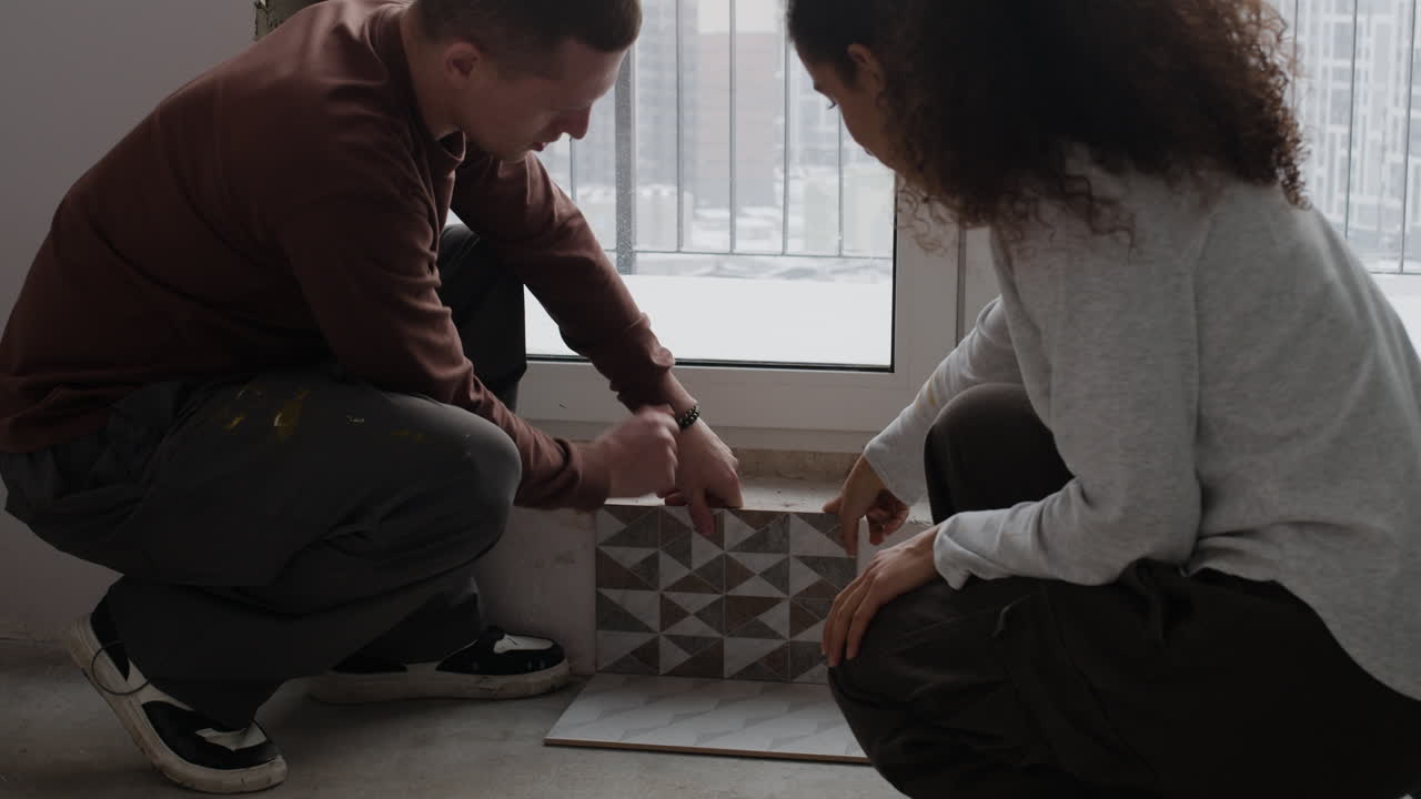 Couple Installing Tiles During Home Renovation