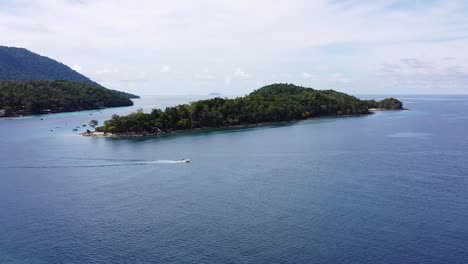 aerial view of fast moving tour boat passing tropical island of pulau rubiah in pulau weh sabang in sumatra, indonesia