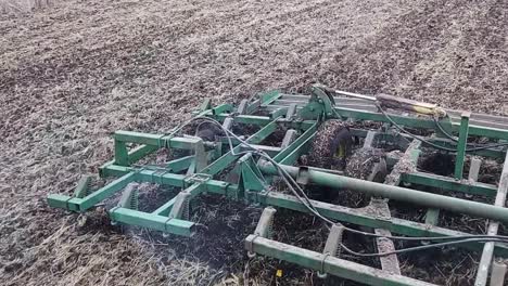 a cultivator working up a field in the springtime